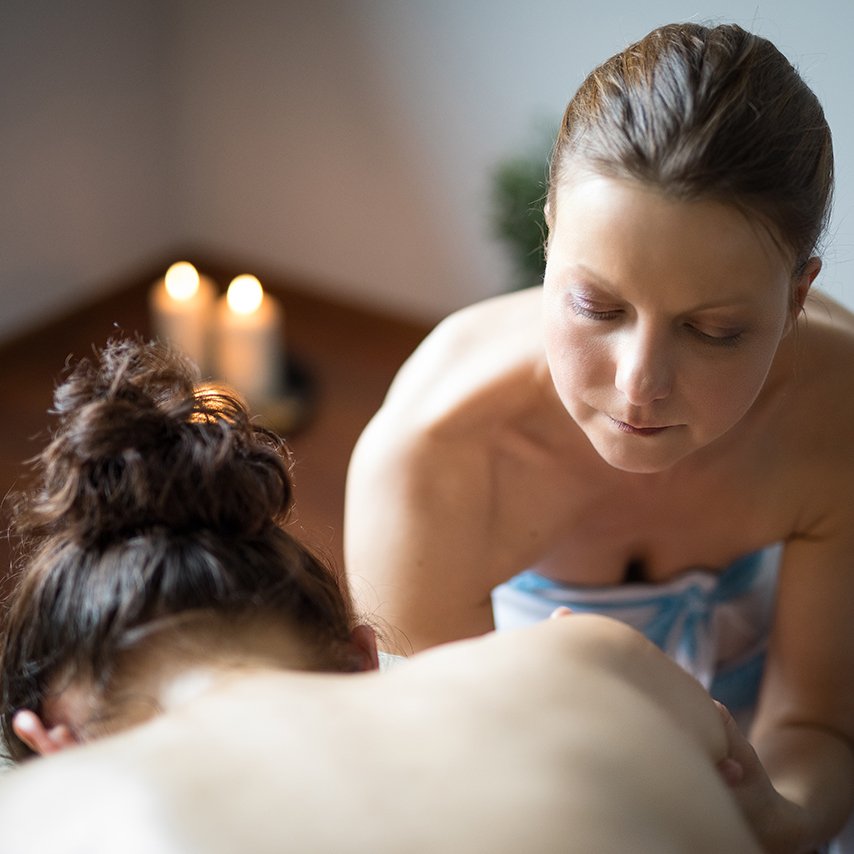 Joanna offering Lomi Lomi massage in a calm, candlelit studio setting
