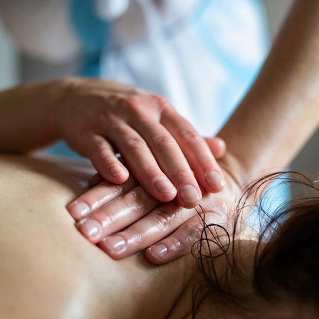 Joanna's hands performing Lomi Lomi energy balancing on a client's upper back