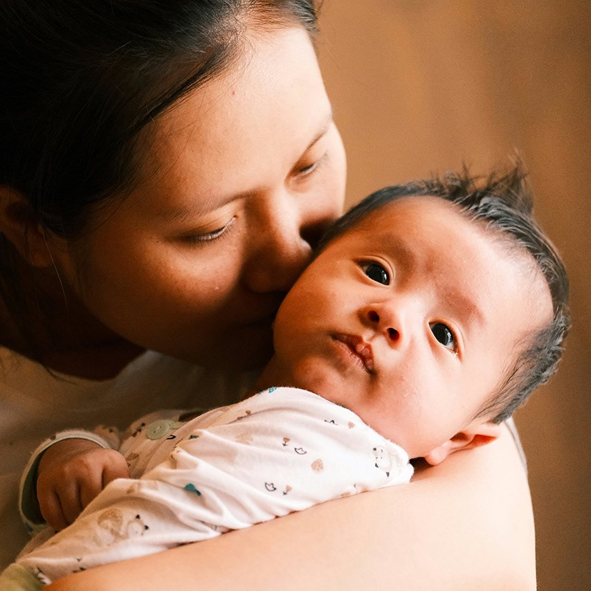Mother holding her child, representing postpartum massage support by Joanna in Berlin